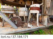 Myshkin city. Myshkin Folk Open-air Museum. National Ethnographic Museum of Wooden Architecture. Millstones of a windmill. Museum exhibits. Resting cat (2011 год). Редакционное фото, фотограф Зобков Юрий / Фотобанк Лори