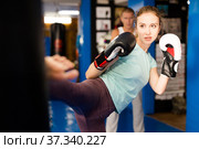 Woman kicking punchbag. Стоковое фото, фотограф Яков Филимонов / Фотобанк Лори