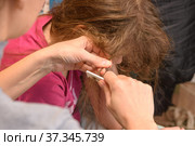 Мама пытается расчесать сильно запутанные волосы девочки, крупный план. Стоковое фото, фотограф Иванов Алексей / Фотобанк Лори