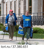 Moscow, Russia - May 31. 2021. LDPR - Liberal Democratic Party of Russia - Members hand out packages of campaign materials to people. Редакционное фото, фотограф Володина Ольга / Фотобанк Лори