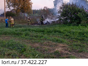 Сотрудники пожарной службы тушат огонь. Пожарные на месте пожара. Пожар в деревне. Горят деревянные дома в деревне Ранцево Тверской области. Fire service employees extinguish the fire. Firefighters at the scene of the fire. A fire in the village. Burning wooden houses in the village of Rantsevo, Tver region. (2021 год). Редакционное фото, фотограф Мария / Фотобанк Лори