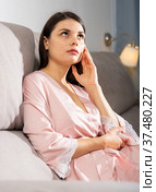 Disappointed girl sitting on sofa in living room. Стоковое фото, фотограф Яков Филимонов / Фотобанк Лори