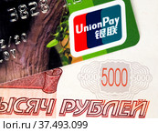 Карта UnionPay на фоне пятитысячной купюры (2022 год). Редакционное фото, фотограф SevenOne / Фотобанк Лори