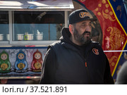 Предпринимателя-ресторатор Ханун Бенагуев на фоне фудтрака Матрешка на Тверской улице в центре города Москвы, Россия (2022 год). Редакционное фото, фотограф Николай Винокуров / Фотобанк Лори