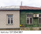 Контраст между кирпичной и деревянной половинами дома (2020 год). Редакционное фото, фотограф Вячеслав Палес / Фотобанк Лори