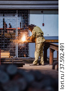 Welder worker welding steel tubes. Factory workshop abstract interior. Стоковое фото, фотограф Alexey Rezvykh / Фотобанк Лори