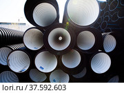 Plastic pipes production plant warehouse. Black and white PVC channelled pipes. Стоковое фото, фотограф Alexey Rezvykh / Фотобанк Лори