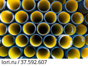 Plastic pipes production plant warehouse. Yellow PVC channelled pipes. Стоковое фото, фотограф Alexey Rezvykh / Фотобанк Лори