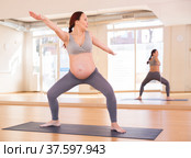 Pregnant woman is engaged in yoga. Goddess Pose or utkata konasana. Стоковое фото, фотограф Татьяна Яцевич / Фотобанк Лори
