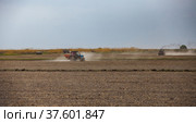 Tractors cultivating field ground for rice seeding. Spring sowing campaign. Panoramic view. Стоковое фото, фотограф Alexey Rezvykh / Фотобанк Лори