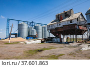 Old Soviet grain storage (right) and modern steel elevator silos (left). Стоковое фото, фотограф Alexey Rezvykh / Фотобанк Лори