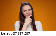 Blonde woman thinking over smart idea, pondering, against yellow background. Стоковое видео, видеограф Сергей Толмачёв / Фотобанк Лори