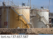 White and yellow oil storage tanks on bright sun on blue sky. Close up. Oil refinery plant in desert. Near Taraz city. Стоковое фото, фотограф Alexey Rezvykh / Фотобанк Лори