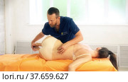 Positive male osteopath treating patient with public lecture. Стоковое видео, видеограф Гурьянов Андрей / Фотобанк Лори