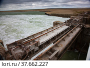 Small Aral Sea Kok-aral dam. Kazakhstan, Kyzylorda region. Concrete supports, metal shutters. turbulent water after dam. Grey storm sky. Стоковое фото, фотограф Alexey Rezvykh / Фотобанк Лори