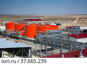 Kzylorda region/Kazakhstan - April 30 2012: Orange steel storage tanks with acid at sulfuric (sulphuric) acid plant warehouse in desert. On blue sky background. Стоковое фото, фотограф Alexey Rezvykh / Фотобанк Лори