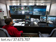 Zhanazhol, Aktobe region, Kazakhstan - May 04 2012: Oil refinery plant. Operational control center (control room). Operator in red work wear monitoring process. CNPC company. Редакционное фото, фотограф Alexey Rezvykh / Фотобанк Лори