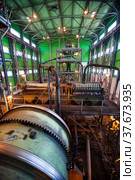 Gold ore Concentrating plant. Ball mill on front. Gold gravity spiral chute concentrator (ore spiral) and magnetic drum separators on background (2012 год). Редакционное фото, фотограф Alexey Rezvykh / Фотобанк Лори