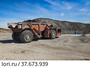 Orange heavy mine truck with gold ore. On empty stones and blue sky background. (2012 год). Редакционное фото, фотограф Alexey Rezvykh / Фотобанк Лори