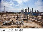 Aktau, Kazakhstan - May 19, 2012 Construction of modern asphaltic bitumen plant. Making reinforcement building columns. Concrete pump truck filling forms. Mixing truck supply a concrete. Редакционное фото, фотограф Alexey Rezvykh / Фотобанк Лори