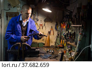 Gunsmith disassembles and repairs pistol in weapons workshop. Стоковое фото, фотограф Яков Филимонов / Фотобанк Лори
