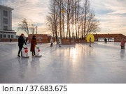 St. Petersburg, Russia - December 10, 2021: Public outdoor ice skating rink in Sevkabel Port. People ice skating, active lifestyle. Редакционное фото, фотограф Юлия Бабкина / Фотобанк Лори