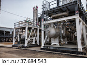 Uralsk region, Kazakhstan - May 24 2012: Oil deposit Zhaikmunai. Grey metal equipment on oil refinery and gas processing plant. Heat exchanger and pipes. Стоковое фото, фотограф Alexey Rezvykh / Фотобанк Лори