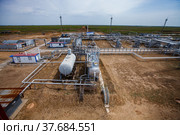 Uralsk region, Kazakhstan - May 24 2012: Oil deposit Zhaikmunai. Oil refinery plant in sand. Heat exchangers, light masts and pipelines. Стоковое фото, фотограф Alexey Rezvykh / Фотобанк Лори