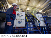 Ekibastuz, Kazakhstan - May 28, 2012. Explosive material production plant for coal quarry mining. Chemical engineer and equipment control panel. Редакционное фото, фотограф Alexey Rezvykh / Фотобанк Лори