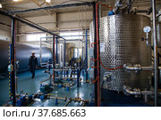 Ekibastuz, Kazakhstan - May 28, 2012. Explosive material production plant. Chemical warehouse, reactor tank and worker on background. Focus on background. Редакционное фото, фотограф Alexey Rezvykh / Фотобанк Лори