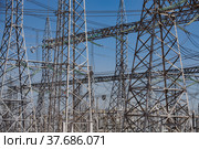 Electrical distributing substation. Pylons and cables. Blue sky background. Стоковое фото, фотограф Alexey Rezvykh / Фотобанк Лори