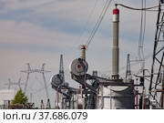Electric transformer with isolators on distributing substation . Blue sky and electric pylons background. Стоковое фото, фотограф Alexey Rezvykh / Фотобанк Лори