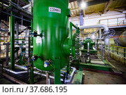 Caustic chemical plant workshop. Green steel tank of chemical reactor and pipelines. (2012 год). Редакционное фото, фотограф Alexey Rezvykh / Фотобанк Лори