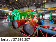 Aksu, Pavlodar region, Kazakhstan - May 29, 2012: Aksu steam power station workshop. Red cones of fire extinguisher system. Electric machine with steam turbine on background. Редакционное фото, фотограф Alexey Rezvykh / Фотобанк Лори