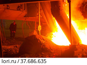 Aksu, Pavlodar region, Kazakhstan - May 29 2012: Metallurgist worker controlling melting process, left. Metal alloy plant, smelter. Electric arc furnace right. Стоковое фото, фотограф Alexey Rezvykh / Фотобанк Лори