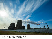 Silhouette panoramic view on Pavlodar thermal power plant. Cooling towers left. Smoke stacks with white smoke right. Blue sky with clouds. Стоковое фото, фотограф Alexey Rezvykh / Фотобанк Лори