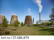 Pavlodar thermal electric station. Cooling towers and smoke stack with white smoke. Green grass field. Стоковое фото, фотограф Alexey Rezvykh / Фотобанк Лори