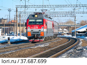Российский современный электровоз ЭП1М-712  на станции Шарья Северной железной дороги солнечным мартовским днем (2022 год). Редакционное фото, фотограф Виктор Карасев / Фотобанк Лори