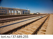 Altynkol, Kazakhstan - June 05, 2012: Railway station Altynkol. Old rusted railroad track with wooden sleepers. Station building on background. Редакционное фото, фотограф Alexey Rezvykh / Фотобанк Лори
