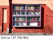Уличный книжный шкаф бля свободного обмена книгами солнечным днем. Кронштад (2022 год). Редакционное фото, фотограф Виктор Карасев / Фотобанк Лори