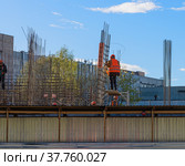 Стройка. Работающие монтажники на площадке. Рабочий вяжут арматуру на строительном участке (2022 год). Редакционное фото, фотограф Grigory_Gez / Фотобанк Лори
