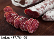 Slicing delicious Spanish smoked sausage fuete. Стоковое фото, фотограф Яков Филимонов / Фотобанк Лори