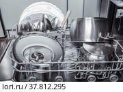 Clean washed dishes, pots, cutlery in the dishwasher. Стоковое фото, фотограф Юлия Бабкина / Фотобанк Лори