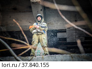 Вооружённый солдат в городских развалинах. Наёмник в промзоне. (2021 год). Редакционное фото, фотограф Виталий Михайлюк / Фотобанк Лори