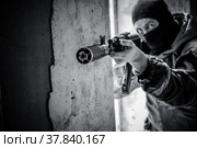 Вооружённый солдат в маске ведёт бой в разрушенном здании.  Городские бои. Спецназ в зоне боевых действий. (2021 год). Редакционное фото, фотограф Виталий Михайлюк / Фотобанк Лори