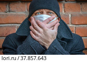 Мужчина в медицинской маске закрывает лицо руками. Защита органов дыхания от вирусной инфекции. Стоковое фото, фотограф Виталий Михайлюк / Фотобанк Лори
