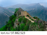 Ancient tower and castle wall on top of a sheer cliff in a mountainous area, Gunib (Shamil) fortress in Dagestan, Стоковое фото, фотограф Евгений Харитонов / Фотобанк Лори