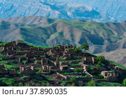Ruins of houses on a mountainside in Kurib, a depopulated village with the only remaining household with an apiary, Dagestan; another village, Chokh, is visible in the distance. Стоковое фото, фотограф Евгений Харитонов / Фотобанк Лори