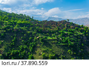 Ruins of houses on a mountainside in Kurib, a depopulated village with the only remaining household with an apiary, Dagestan; another village, Chokh, is visible in the distance. Стоковое фото, фотограф Евгений Харитонов / Фотобанк Лори