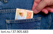 Swedish krona banknotes being taken out of a jeans pocket. Стоковое видео, видеограф FotograFF / Фотобанк Лори